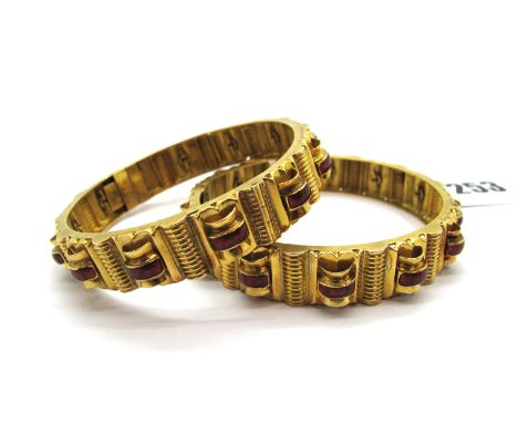 A Pair of Indian Bangles, each of geometric textured design, with red enamel highlights, hinged to snap clasp, stamped "22,C"