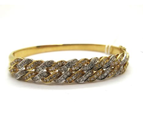 A Modern Two Row Two Colour Diamond Set Bangle, set throughout with brilliant cut stones, hinged to snap clasp, stamped "585"