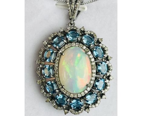 Large and exciting oval cluster pendant in silver, set with oval cabochon opal surrounded by R/C diamonds and oval London blu