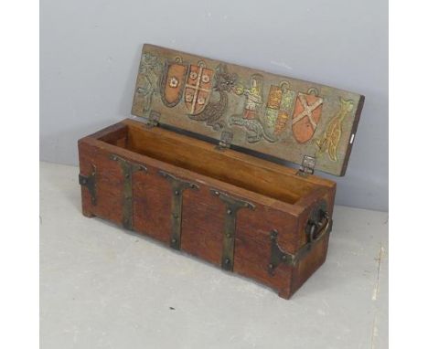 A metal bound teak trunk, the lid lifting to reveal armorial mythological carved and painted designs. Width 75cm, height 30cm