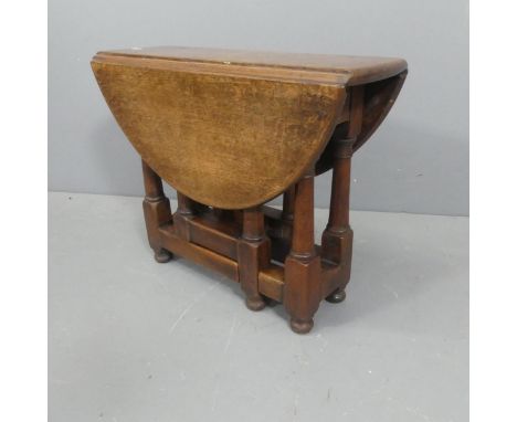 An antique oak oval gate-leg drop-leaf occasional table. Length 59cm, height 49cm, depth 23cm.