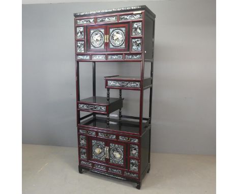 A modern Korean two-section black and red-lacquered display cabinet, with four cupboard doors, five drawers and inlaid mother