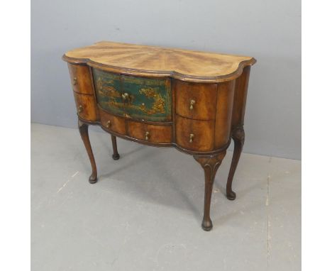 An early 20th century mahogany side table of scalloped form, with painted chinoiserie decoration, two cupboards and six drawe