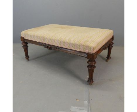 A Victorian walnut and upholstered footstool. Width 108cm, height 45cm, depth 70cm.