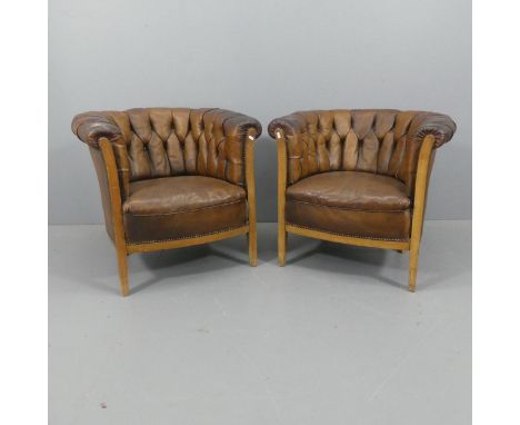 A pair of early 20th century walnut and studded leather button-back upholstered tub chairs. Overall width 80cm, height 73cm, 
