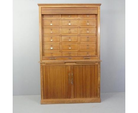 A vintage French oak two-section tambour-front notaire cabinet, the upper section having eighteen fall-front compartments, th