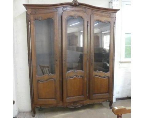 A French oak bookcase, with three glazed doors and four adjustable shelves (lacking supports). Width 182cm, height 213cm, dep