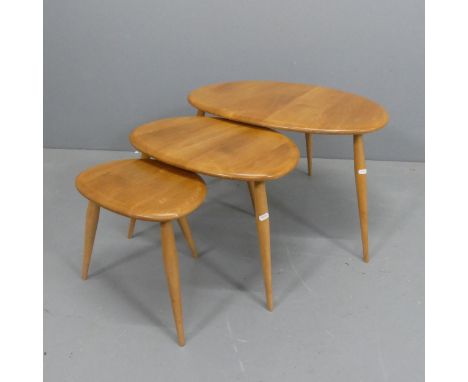 ERCOL - A nest of three pebble occasional tables, with blue maker's label. Largest width 66cm, height 39cm, depth 44cm.