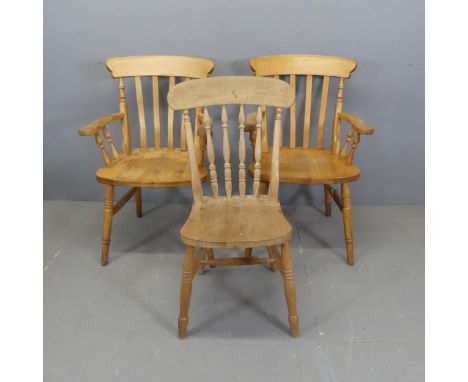 A pair of pine stick-back elbow chairs, and a similar dining chair. (3)