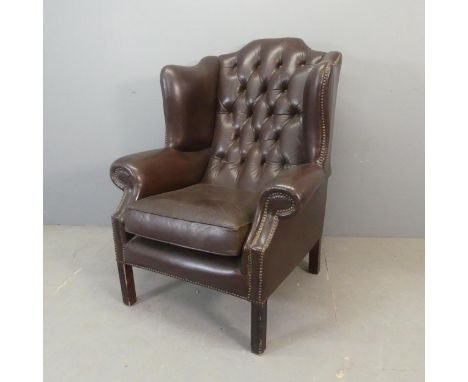 A button-back studded faux-leather upholstered wingback armchair.Some use related marks, and small chips to veneer around bot