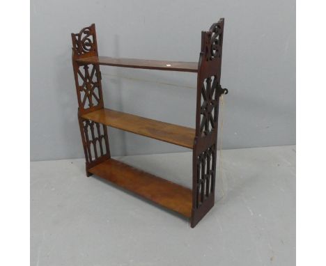 A Victorian Arts &amp; Crafts mahogany three tier hanging shelf. Width 62cm, height 69cm, depth 16cm.