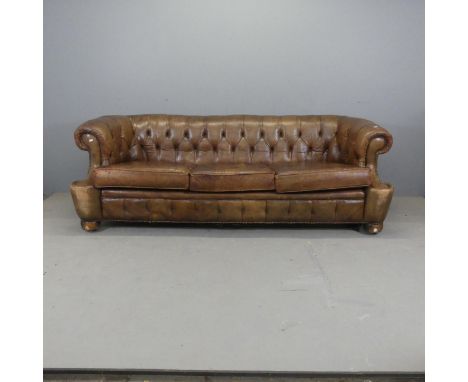 An antique brown button-back studded-leather upholstered Chesterfield sofa. Overall width 215cm, height 75cm, depth 90cm, sea