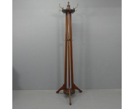 A Victorian Arts &amp; Crafts mahogany hall stand, with rotating coat hooks, fluted decoration and tripod base. Height 205cm.