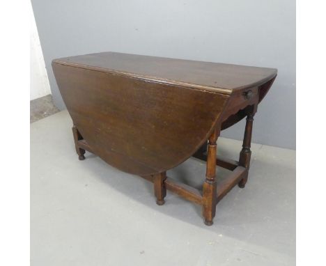 A 19th century oak oval gate-leg drop-leaf dining table, with turned legs and two end frieze drawers. Length 132cm, height 70