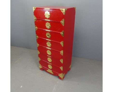 A Korean red-lacquered kiriwood Tansu chest of seven drawers, with brass mounts and pulls. Width 61cm, height 137cm, depth 41