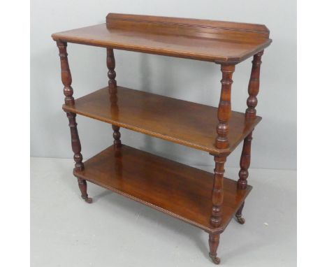 A Victorian mahogany three-tier buffet, with turned supports and brass casters. Width 92cm, height 103cm, depth 40cm.