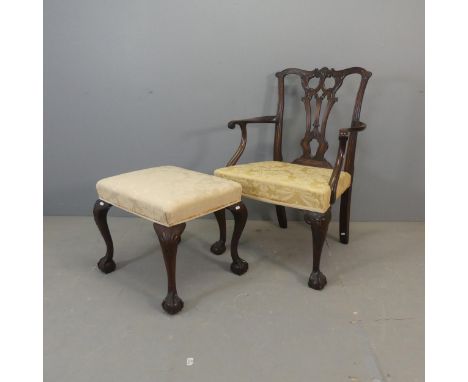 A 19th century Chippendale style open arm chair with carved decoration and cabriole legs, and a similar footstool. (2)Dimensi