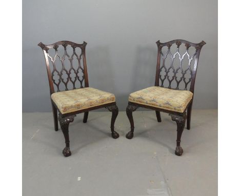 A pair of late 19th / early 20th century Chippendale style chairs, with lattice backs, cabriole legs and claw and ball feet.