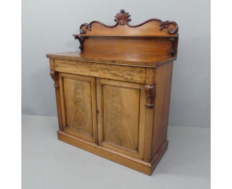 A Victorian mahogany chiffonier with raised back, carved decoration, flame veneered doors and plum-pudding top.. Width 107cm,