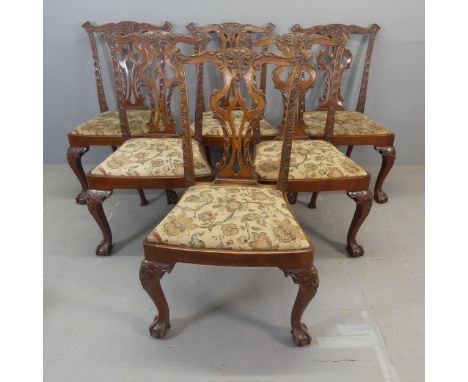 A set of six antique mahogany Chippendale style dining chairs, with all-over carved decoration, upholstered drop in seats and