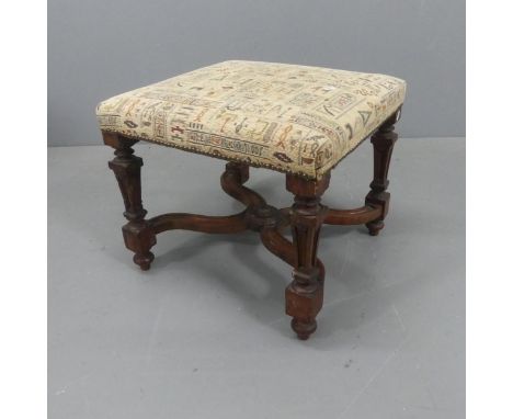 A French mahogany and upholstered footstool, with x-shaped stretcher and carved decoration. Width 53cm, height 46cm, depth 50