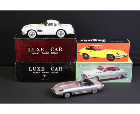 Four boxed tin plate friction powered models to include Standard Sedan in white with pink hood, Lemezaru Gyar Jaguar in silve