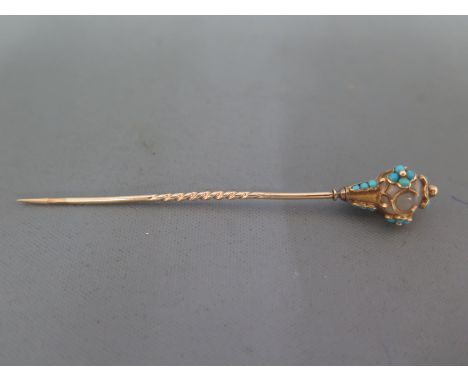 An unmarked stick pin with central circular probably rock crystal surrounded with small circular turquoise dotsCondition repo