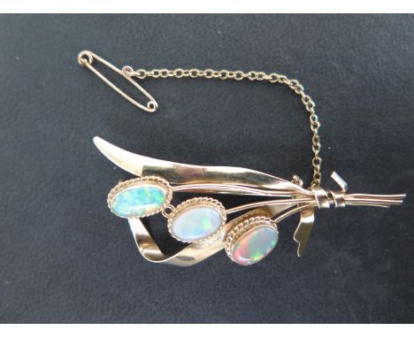 A 10ct gold and opal brooch in the form of a spray of flowers, each opal approx. 9 x 5 mm - brooch length 5.5cm - Total weigh