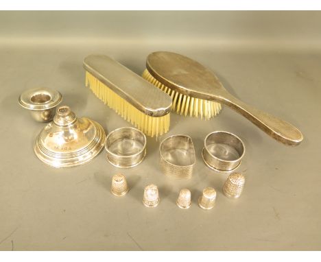 Three hallmarked silver napkin rings, five silver thimbles, a silver handled hairbrush, a silver handled clothes brush and a 