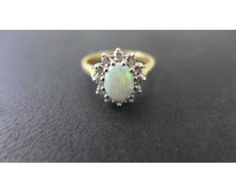 An 18ct gold opal and diamond ring size P - approx 5.3 grams - size of opal is approx 8mm x 5mm - diamonds bright, opal fiery