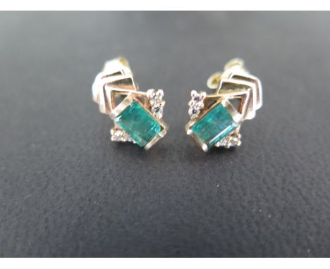 A pair of emerald and diamond earrings set  in 18ct yellow gold, each emerald approx. 6mm x 4mm, flanked by two small diamond