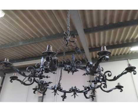 A pair of large, circular nine branch pendant ceiling electric light fittings, each with fleur de lis detail, 106cms diameter