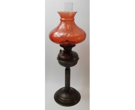 A 20th century brass table lamp, with a reeded stem and cranberry glass shade, 64cm high,