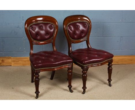 Pair of 19th century mahogany and red leather button down chairs, having balloon shape back rests, raised on sabre back legs 
