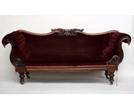 A late Regency walnut sofa, possibly Irish, with foliate carved upholstered back and S-scroll arms, on turned legs