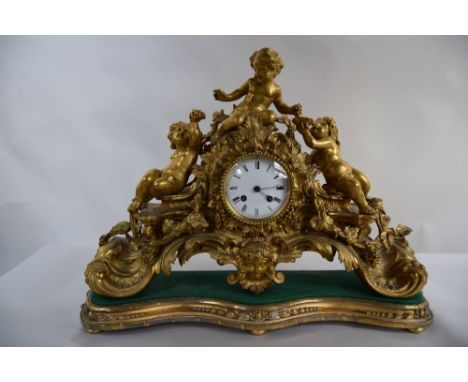 A late 19th century gilt metal mantel clock, three boys sitting atop vines, enamel dial with Roman numerals signed to bottom,