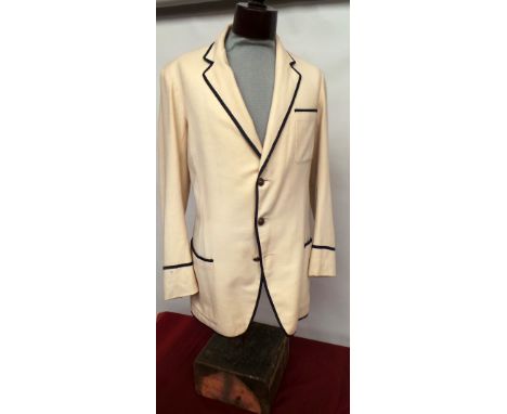 A vintage 'Gieves' college blazer in cream wool with black piping to collar, cuffs and pocket tops.