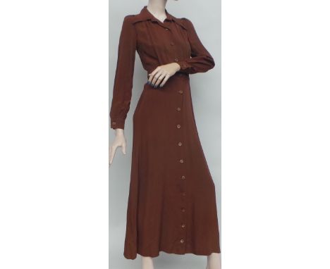 A 1960s/70s Bus Stop brown crepe maxi dress. The dress is long sleeved and buttons down the front to fasten. The bodice has a