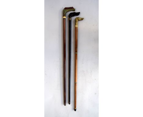 A Victorian ebony walking stick with carved criss-cross body, brass collar and ebony dogs head handle, 88cm, with another dog