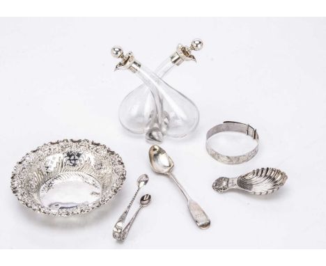 A group of six silver collectables, including a circular bon bon dish, a tea caddy spoon, a teaspoons, a bangle, a pair of to