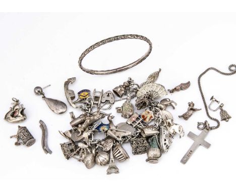 A silver charm bracelet,  with multiple charms including a cable car, fan, cine camera, Matador, bull, pair of ski's, an alad
