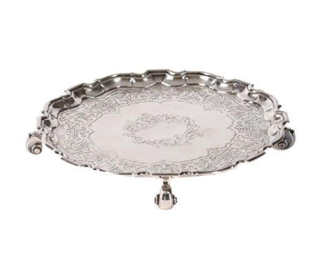 A GEORGE III SILVER SHAPED CIRCULAR SALVER MAKER'S MARK D ..., LONDON 1776 With a raised moulded border, engraved with foliat