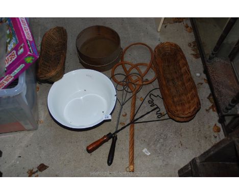 An enamel bowl, carpet beaters and wicker baskets.