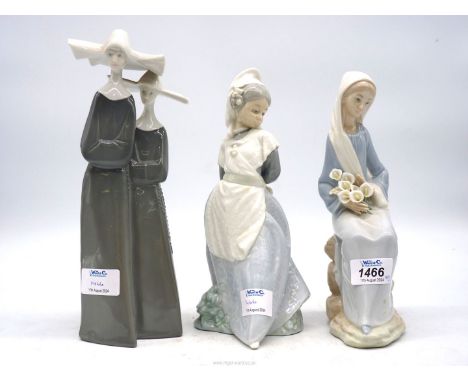 Three figures to include grey and white Nuns, Lladro Lady with lilies, 9 1/2" tall and Nao Girl holding bouquet of flowers, 9