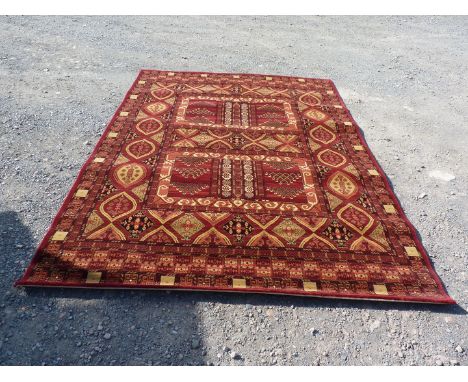 A bordered and patterned red ground Carpet in geometric pattern, 111 1/2" x 78 3/4".