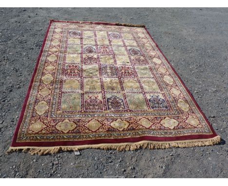 A Bordered, patterned and fringed Carpet with multiple floral panels to centre on a red ground, 116" x 78 1/4".