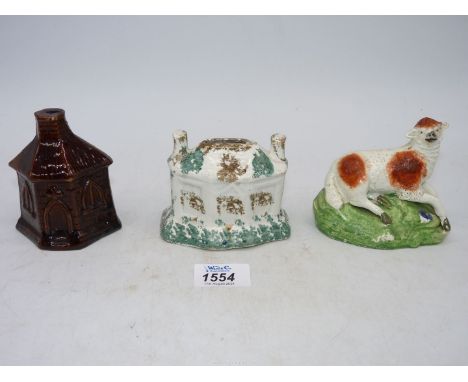 Two early pottery cottage Money Boxes and a sheep, one house with sponge ware decoration, the other with a dark treacle glaze