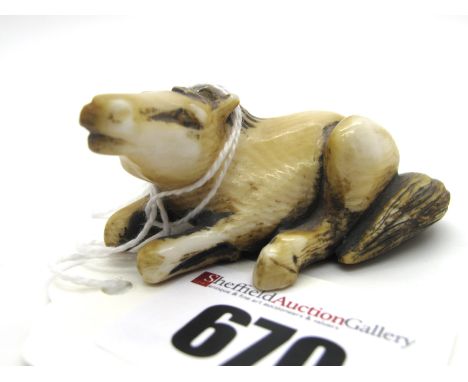 A Late XIX Century Japanese Ivory Netsuke, carved as a recumbent horse, signed, 6cm long.