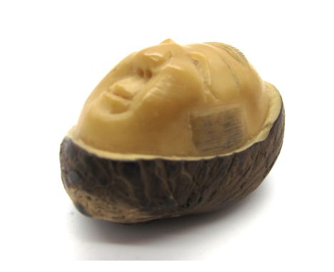 A Late XIX Century Japanese Tagua Nut Netsuke, carved with a Hyottoko mask, signed, 3.5cm long.