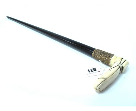 A Late XIX Century Walking Stick, the ivory handle carved as a boot, the embossed mount with vacant shield, stamped "18ct", 9